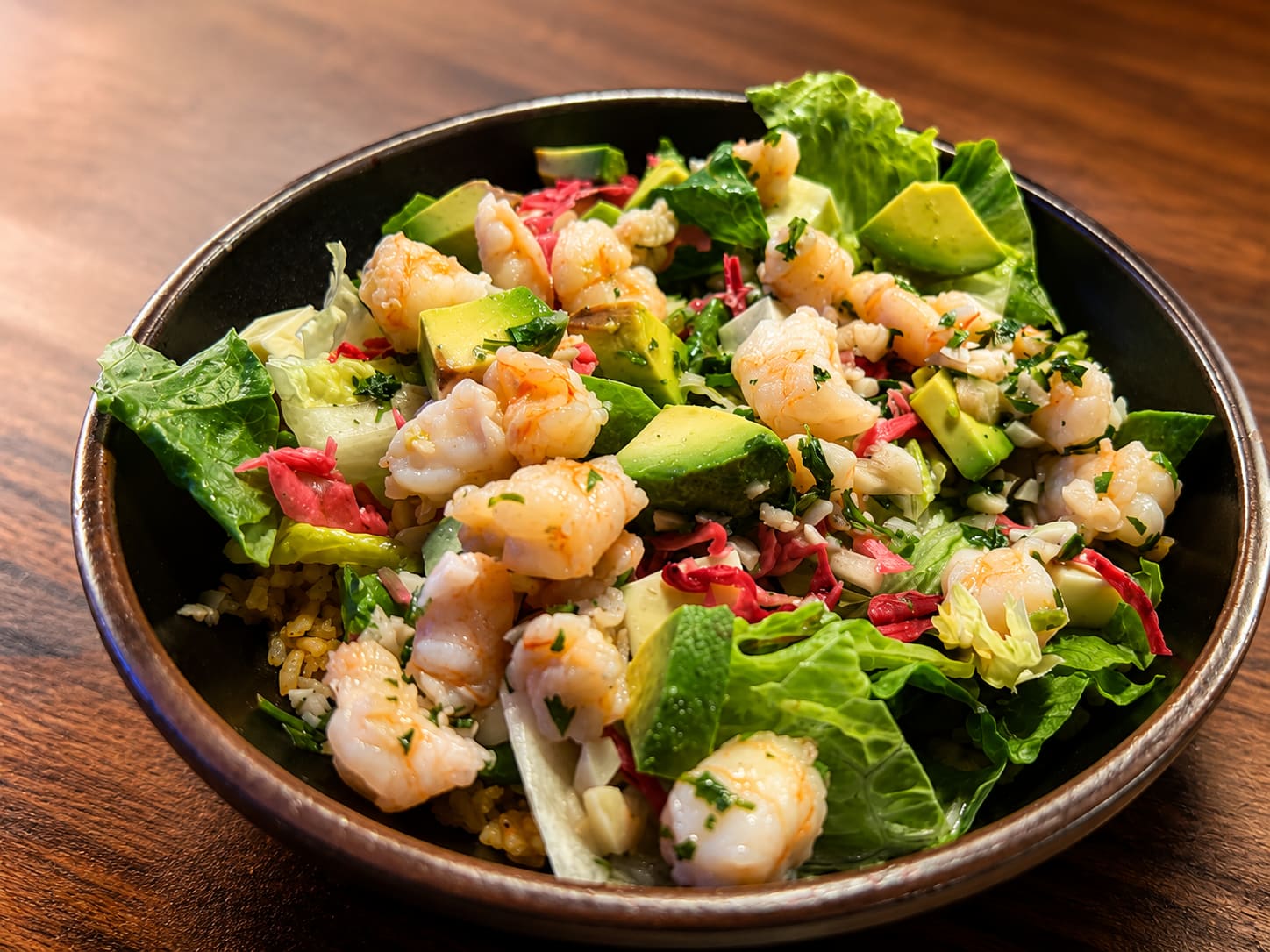 Abuela’s salad topped with sautéed shrimp, avocado and pickled cabbage.